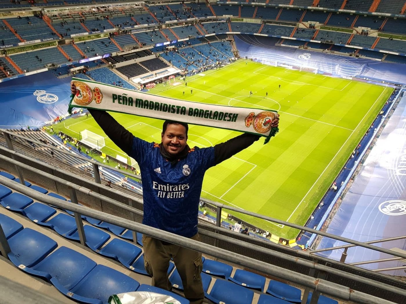 A PMBD official member holding a Peña Madridista Bangladesh scarf in the stands at the Santiago Bernabéu