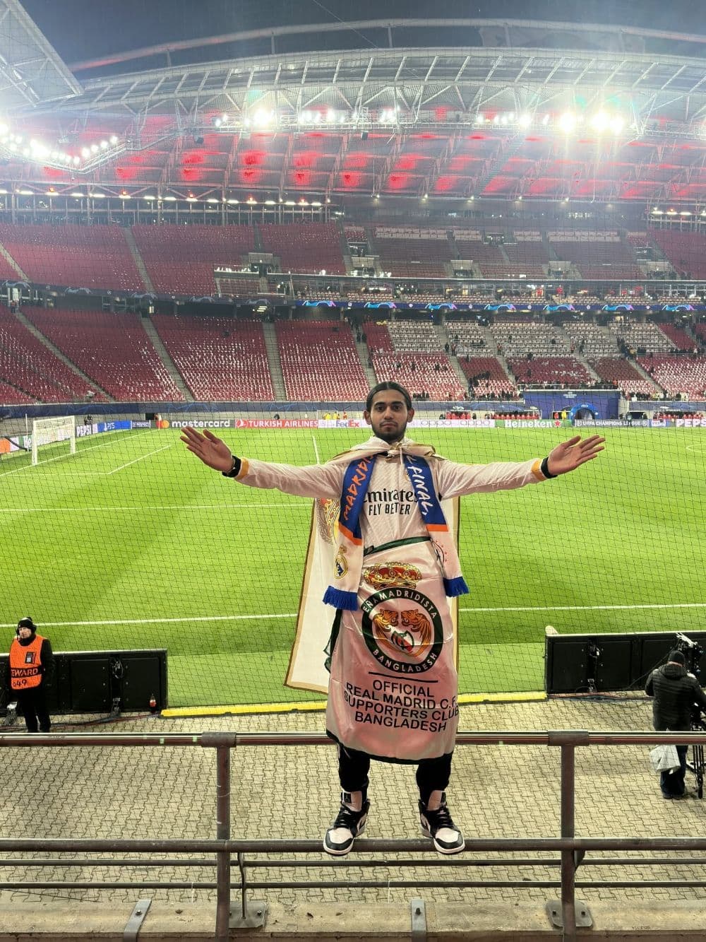 A PMBD member wearing the official Peña Madridista Bangladesh flag in the away section at RB Leipzig